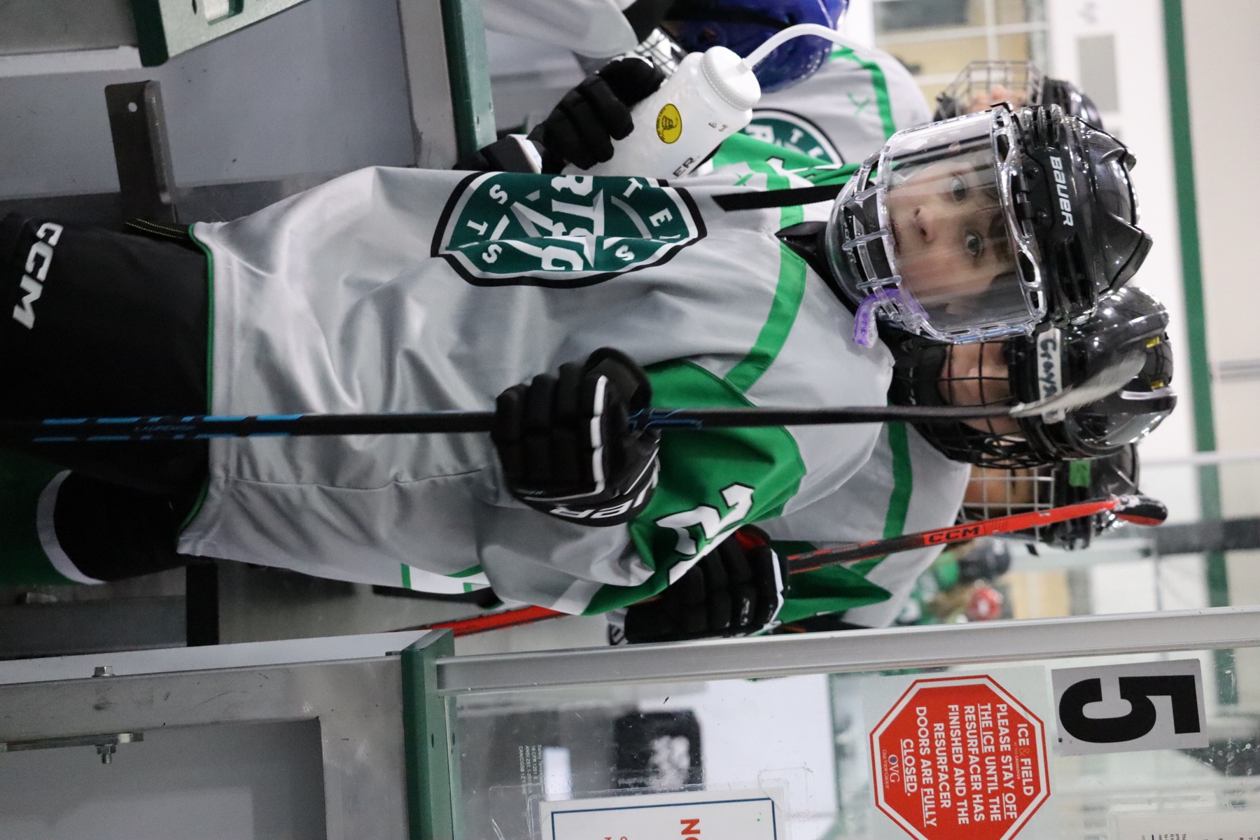 Youth hockey player waiting near the rink gate